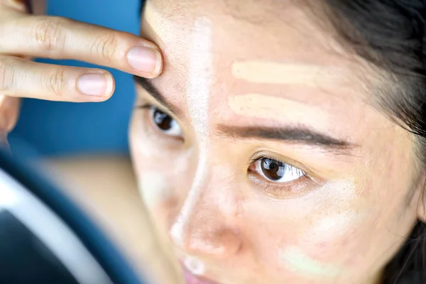 Asiatisk kvinna sminkning, kosmetika stiftelse använder för att korrigera eller gömma ansiktet hudproblem, lärande gör själv makeup. — Stockfoto