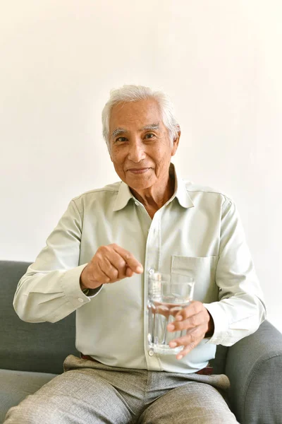 L'acqua potabile è buona abitudine sana per il vecchio, anziano sorridente uomo asiatico che punta al vetro di acqua purificata, concetto di assistenza sanitaria senior . — Foto Stock