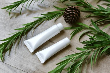 Yeşil bitkisel yapraklarla paketlenmiş kozmetik şişe kapları, organik markalaştırma için boş etiket, doğal cilt bakımı ürün konsepti.