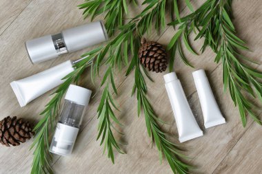 Yeşil bitkisel yapraklarla paketlenmiş kozmetik şişe kapları, organik markalaştırma için boş etiket, doğal cilt bakımı ürün konsepti.