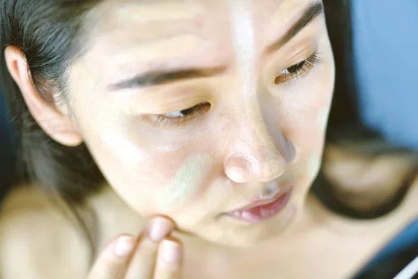 Mujer asiática aplicando maquillaje cosmético y usando corrector de color corrector corrector, aprendiendo haciendo maquillaje personal . — Foto de Stock