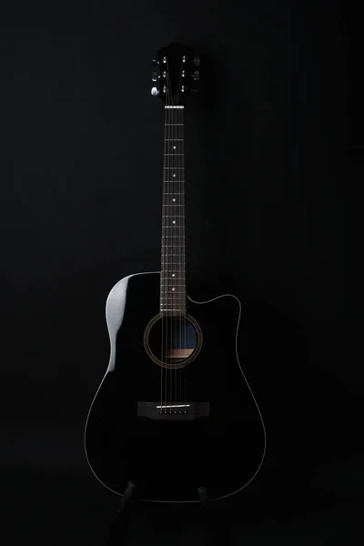 Black acoustic guitar studio shot on black background with copyspace, Guitar is favorite music instrument for hobby.