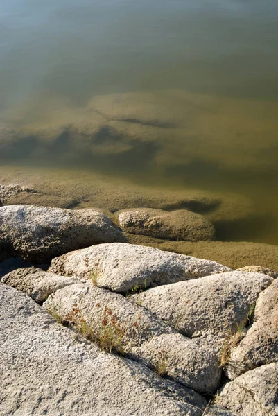 Rio com uma costa rochosa. Textura com água e granito — Fotografia de Stock