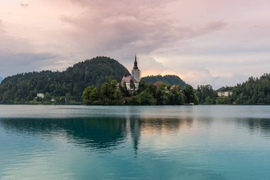 Bled Gölü Adası ve kilise ile. Mavi su ve fırtına bulutları.