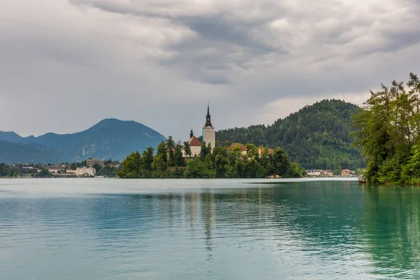Church on the Bled lake island. Dark gray sky after storm.