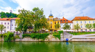 Ljubljana eski kasaba merkezi, şehir merkezindeki Ljubljanica nehrinin manzarası. Tarihi bina manzarası. Turistle eski köprüye bak.