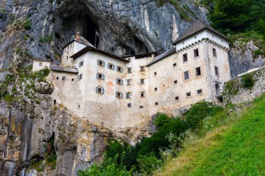 Predjama Kalesi, Slovenya. Postojna yakınındaki Predjama Kalesi'nin doğal görünümü mağara ağzını. Anciend mimari kayaya inşaatı. Eski Ortaçağ Kalesi, güneşli yaz gün