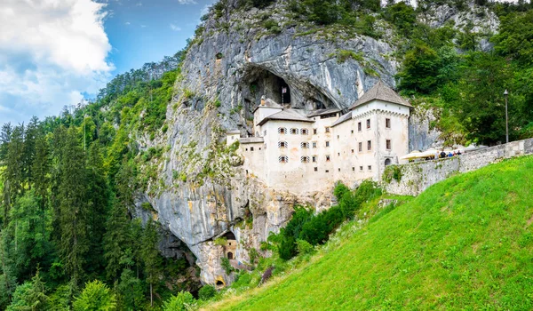 Predjama Kalesi, Slovenya. Postojna yakınındaki Predjama Kalesi'nin doğal görünümü mağara ağzını. Anciend mimari kayaya inşaatı. Eski Ortaçağ Kalesi, güneşli yaz gün