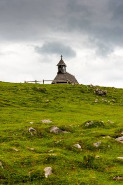 Kilise Slovenya büyük Plato arazide (Velika Planina). Chapel Hill, din sembolü. Yeşil çayır ve mavi gökyüzü bulutlu. Kamnik kenti yakınlarındaki Plato.