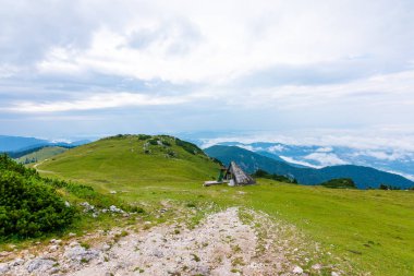 Slovenya Alps etmek görünümüne şehir Kamnik yakınlarında. Mera ve ahşap evler büyük Yaylası. Yeşil çim ve bulutların üzerinde tepeden manzara