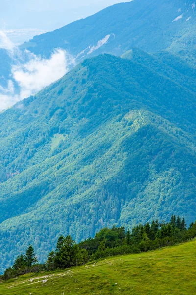 Dramatic and majestic clouds on Slovenia mountains. Clouds above the big mountain in summer weather. Nature landscape of great tourist target in julian alps. Trip and trail in big mountains