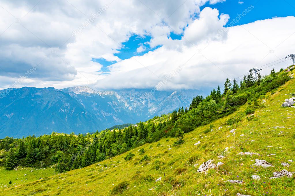Dramatic and majestic clouds on Slovenia mountains. Clouds above the big mountain in summer weather. Nature landscape of great tourist target in julian alps. Trip and trail in big mountains