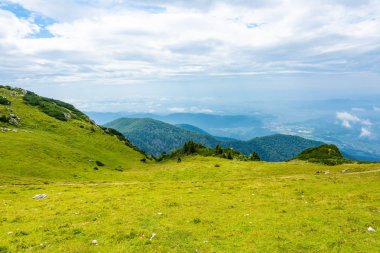 Slovenya dağlar Velika Planina mera arazi üzerinde Kamnik city yakınındaki. Görünüm beyaz bulutlar ve mavi gökyüzü ile dağlarında hill sis. Güzel ve sakin doğa, taze çimen.