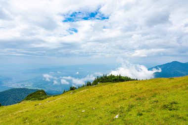 Slovenya dağlar Velika Planina mera arazi üzerinde Kamnik city yakınındaki. Görünüm beyaz bulutlar ve mavi gökyüzü ile dağlarında hill sis. Güzel ve sakin doğa, taze çimen.