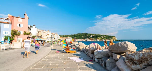 Piran, Slovenya - 24.7.2018: Piran Sahili ve Adriyatik Denizi kumsalda. Turist denizde yüzme veya şehir sokak üzerinde yürüme. Yaz hava, mavi gökyüzü. Ortaçağ şehir, seyahat ve Turizm hedef.