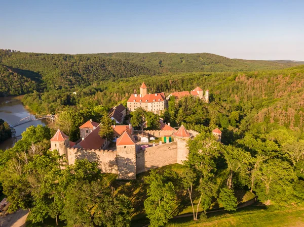 Foto aérea del castillo de Veveri cerca de la ciudad de Brno. Región de Moravia del Sur, rodeada por el río Svratka. Día de verano con cielo azul, puesta de sol y luz suave . — Foto de Stock