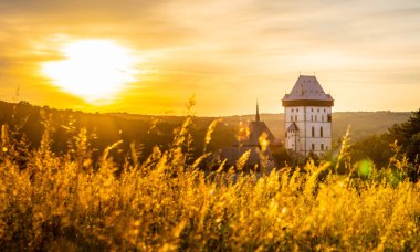 Çek Cumhuriyeti 'nin ünlü şatosu Karlstejn' in üzerinde güzel bir günbatımı. Eski Roma İmparatoru IV. Charles tarafından Gotik tarzda inşa edilmiş bir ortaçağ kalesi. Dramatik gökyüzü, canlı renkler.