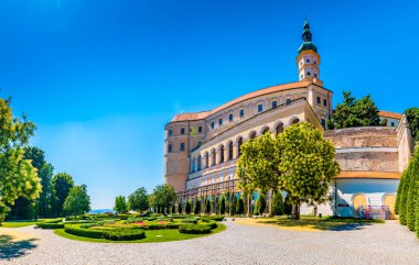 Mikulov Kalesi, Çek Cumhuriyeti. Tepedeki ünlü ortaçağ kalesi. Çiçekleri, ağaçları ve yeşil otları olan güzel bir süs bahçesi. Yaz havası ve mavi gökyüzü. Palava yakınlarında güzel bir şarap bölgesi