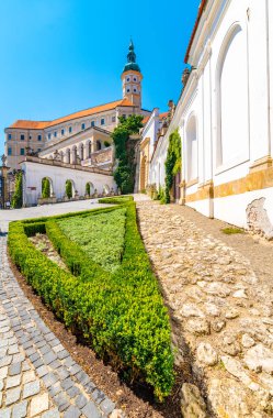 Mikulov Kalesi, Çek Cumhuriyeti. Tepedeki ünlü ortaçağ kalesi. Çiçekleri, ağaçları ve yeşil otları olan güzel bir süs bahçesi. Yaz havası ve mavi gökyüzü. Palava yakınlarında güzel bir şarap bölgesi