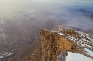 Uçurumun kenarında. Kanyon ve nehir manzarası, dağ sıraları ve savunma ve askeri kuleleri olan antik Aul Goor. Doğa ve seyahat. Rusya, Kuzey Kafkasya, Dağıstan, Shamilsky Bölgesi