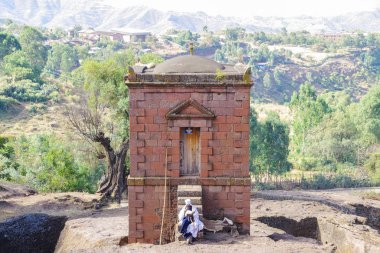 Lalibela, Amhara Bölgesi, Etiyopya - 14 Ocak 2014: Kutsal kitap Selassie kilisenin basamaklarında oturan elinde rahiple.