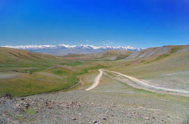 Moğol Altai. Dağ geçidi. Karla kaplı dağların arka planda manzaralı vadi. Kir yollarının konfluence güzel görünümü. Doğa ve seyahat. Moğolistan, Bayan-Olgii Eyaleti