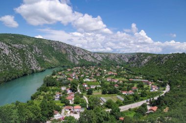 Renkli mavi bulutlu gökyüzünün bir arka plan üzerinde dağ, vadi ve nehir manzara. Neretva nehri boyunca doğal karst amphiteatre. Doğa ve seyahat. Bosna Hersek, Pocitelj