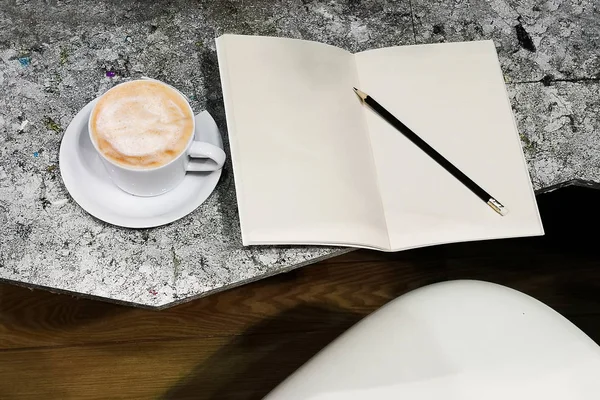 Book with coffee cup on the table.