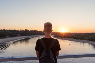 su üstünde çelik korkuluk ile rıhtımda sırtını bir sırt çantası ile genç bir adamla biri