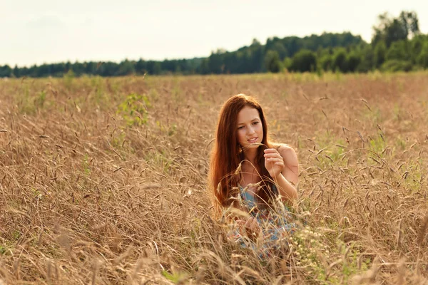 Молодая Девушка Рыжими Волосами Внимательно Рассматривает Колосья Пшеницы Сельском Поле — стоковое фото