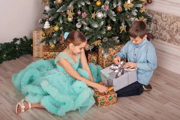 Αγόρι Και Κορίτσι Κάθονται Κοντά Ένα Δέντρο Νέο Έτος Και — Φωτογραφία Αρχείου
