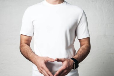 Boş beyaz t-shirt, stüdyo yakın çekim, boş duvar genç atletik erkek