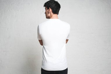 Genç atletik giyen boş beyaz t-shirt, arka yüzüne, yatay stüdyo portre adam