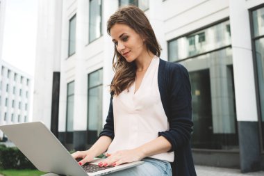Açık kadın öğrenci iş üstünde laptop klavye üzerinde açık havada içinde kentsel görülmektedir. Yakın çekim kadın serbest meslek metin mobil bilgisayarda yazarak