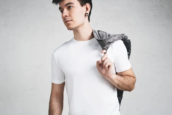 Young man with stubble in blank t-shirt and jacket. Studio portrait, horizontal