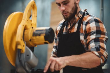 Servis İstasyonu elektrikli taşlama tezgahı üzerinde hizmet makinist sakallı. Makinelerin hizmet. Fabrikada iş akışı. Yatay