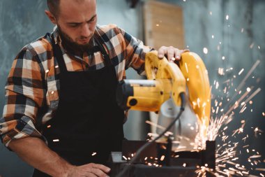 Güçlü metal işleme fabrikası, kıvılcım sinek ayrı elektrik Köşeli taşlama makinesinde çalışan erkeğin sakallı. İş akışı tesisi
