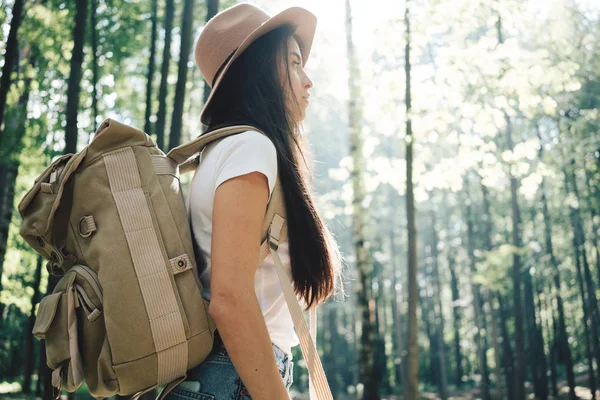 Yakışıklı seyahat etmek sırt çantası ve şapka ayakta ormandaki kadınla. Genç hippi kız on sunset ağaçlar arasında yürüyüş