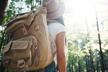 Yakışıklı seyahat etmek sırt çantası ve şapka ayakta ormandaki kadınla. Genç hippi kız on sunset ağaçlar arasında yürüyüş