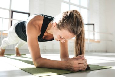 Sabah güneşli beyaz sakız onun abs geliştirmeye tahta egzersiz yaparken genç atletik yerleştirmek. Crossfit egzersiz yaparken spor salonunda spor kadın 