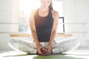 Genç sgtrong kadın fitness mat beyaz interrior spor salonunda germe çekirdek yapıyor. Uygun kadın fitness eğitimi erken sabah sağlık kulübü