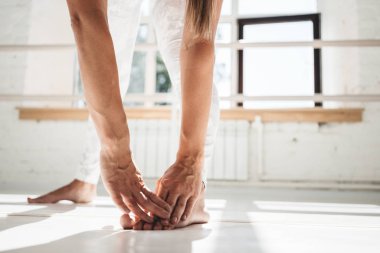 Closeup görünümü uzanan bacaklar ve eller uygular. Genç kadın pratik yoga kapalı