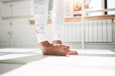 Ayak parmakları ve tozluk kapalı güneşli spor salonu giyen germe egzersizleri yapıyor closeup görünümü uygun kadın ayak üzerinde duruyor