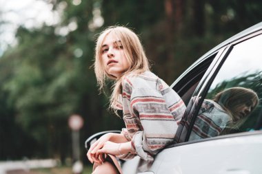 Orman yolu zevk araba pencereden dışarı asılı giyen güzel hipster kadın. Boho tarzı. Yolculuk tutkusu