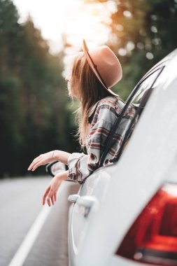 Ormandaki güzel görünümü penceresinden bakıp arabada oturan yakışıklı kadın. Ülkede yol zevk güzel kız hippi. Yaşam tarzı kavramı