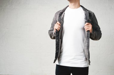 Gülümseyen adam beyaz boş t gömlek ve ceket. Stüdyo yatay dikey