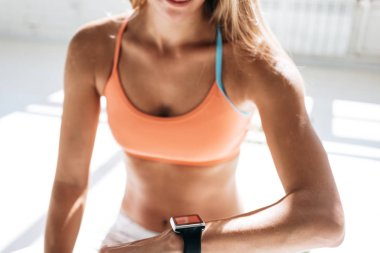 Egzersiz oturum smartwatch fitness uygulama sonuçlarına denetledikten sonra akıllı izlemek ve sayımları harcanan kalori kadar kadın bakar güneşli spor salonunda eğitimden sonra yerleştirmek. Sağlıklı kavramı