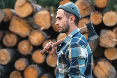 Güçlü oduncu tutar balta ambar günlüklerinin omzuna sakallı