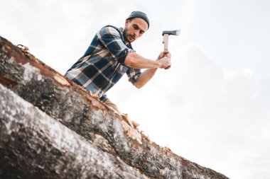 Ekose gömlekli güçlü oduncu ağacı ahşap keskin balta ile pirzola, balta, talaş sinek kadar yakın. Yatay, bulanık arka plan