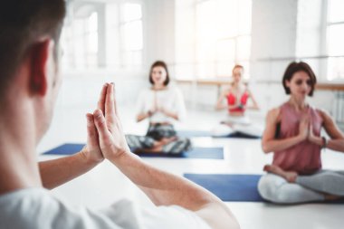 Isınma ve fitness eğitim sınıfında yapıyor kadın ve erkek grubu. Genç aktif insanlar birlikte yoga yapıyor. Sağlıklı yaşam konsepti